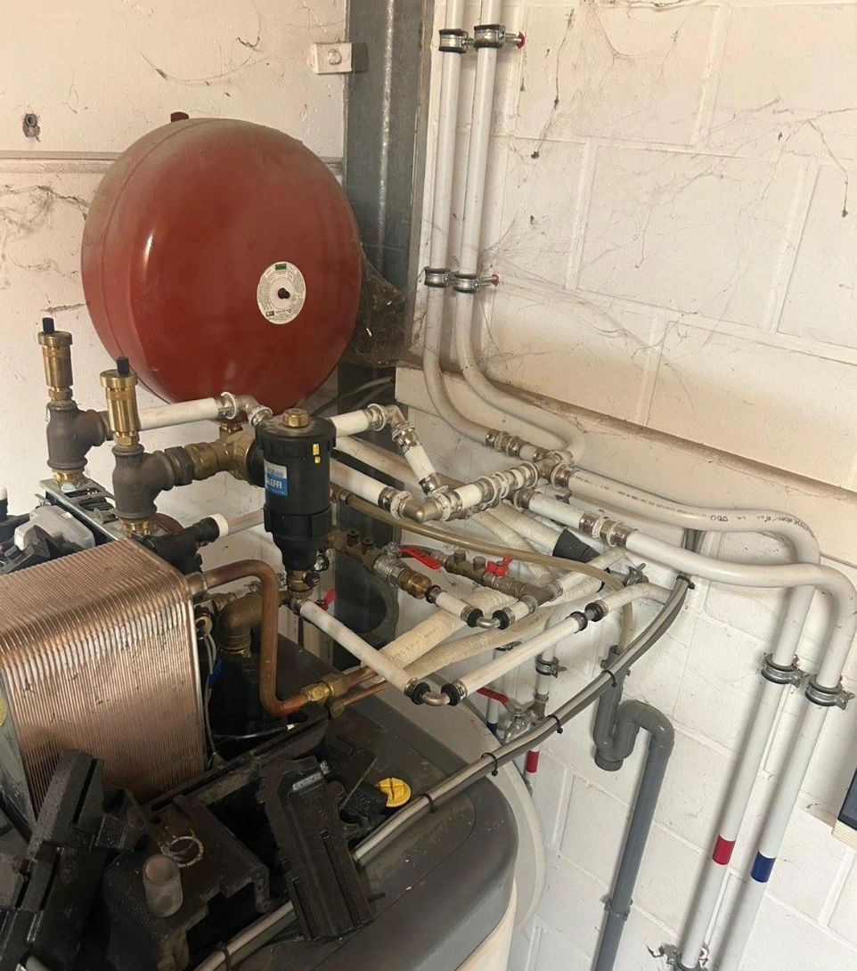 Détail de la chaufferie intérieure avec un vase d'expansion rouge